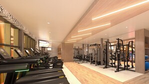 Un gimnasio moderno con cintas de correr, máquinas de pesas y un espejo grande.