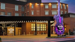 Un hotel Hard Rock con una llamativa escultura de guitarra, amplias ventanas y una zona de entrada cubierta.