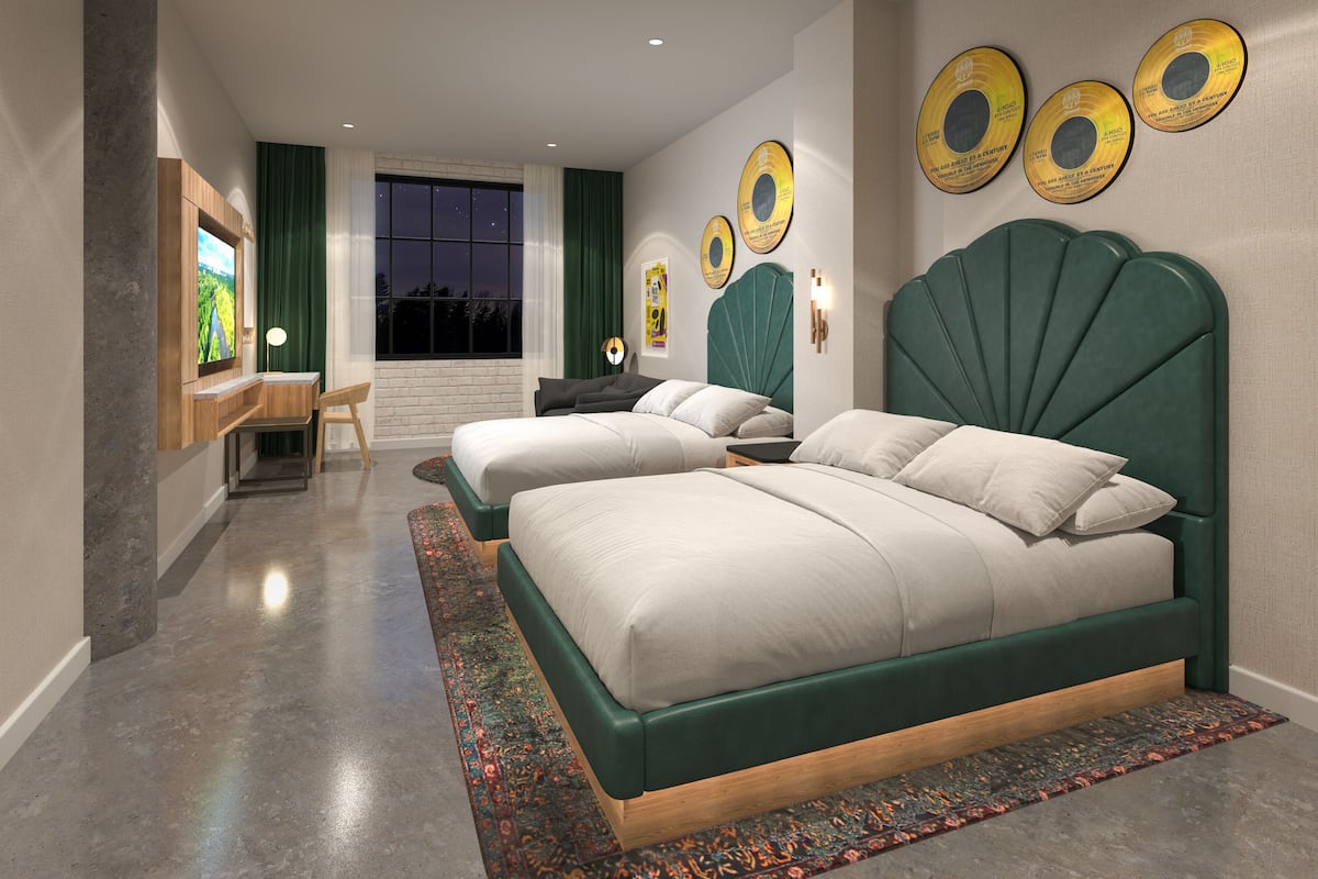 Une chambre moderne avec deux lits, une grande fenêtre et des œuvres d’art décoratives au mur.