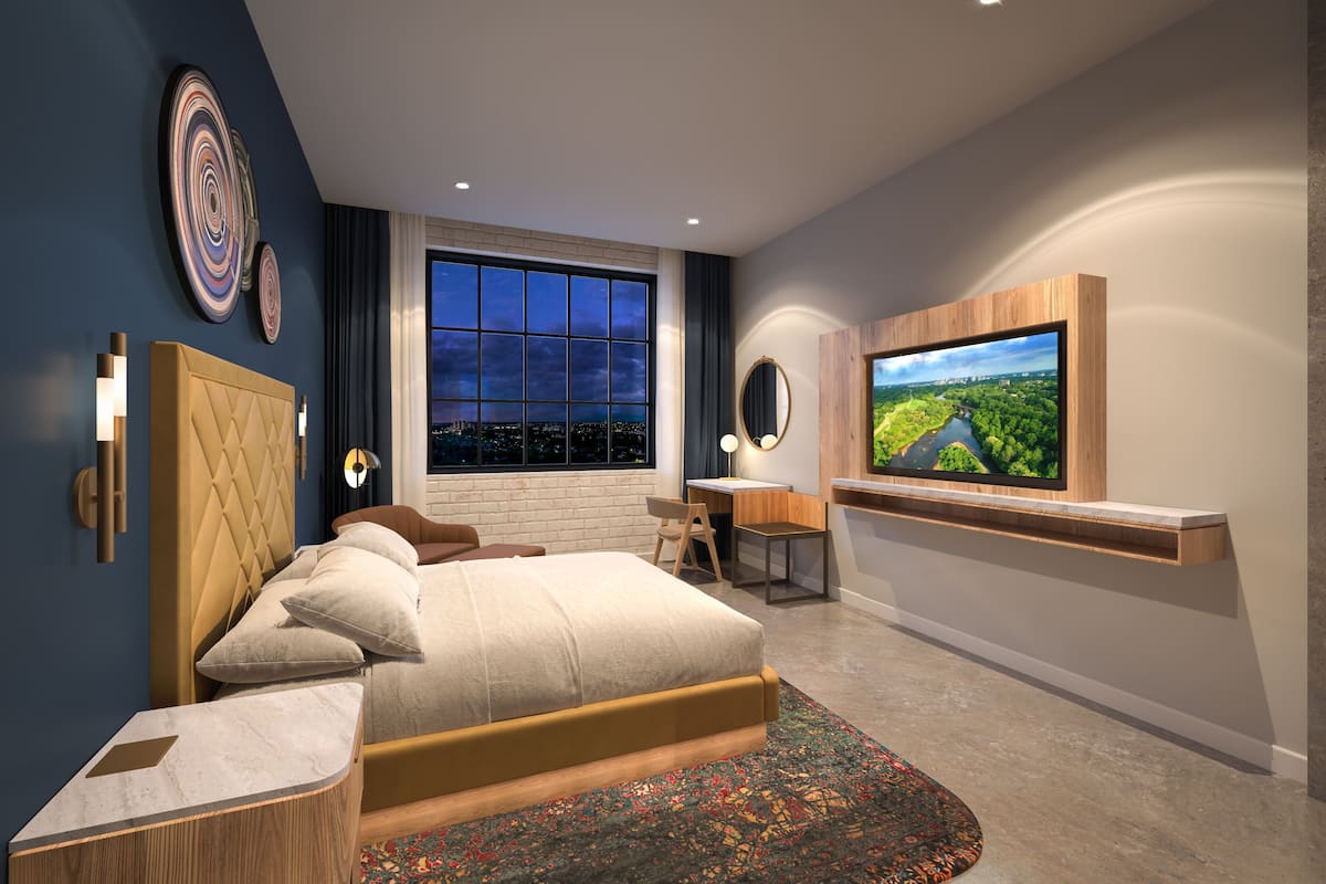 Une chambre moderne avec un grand lit, un bureau, une télévision et une vue sur la ville la nuit.