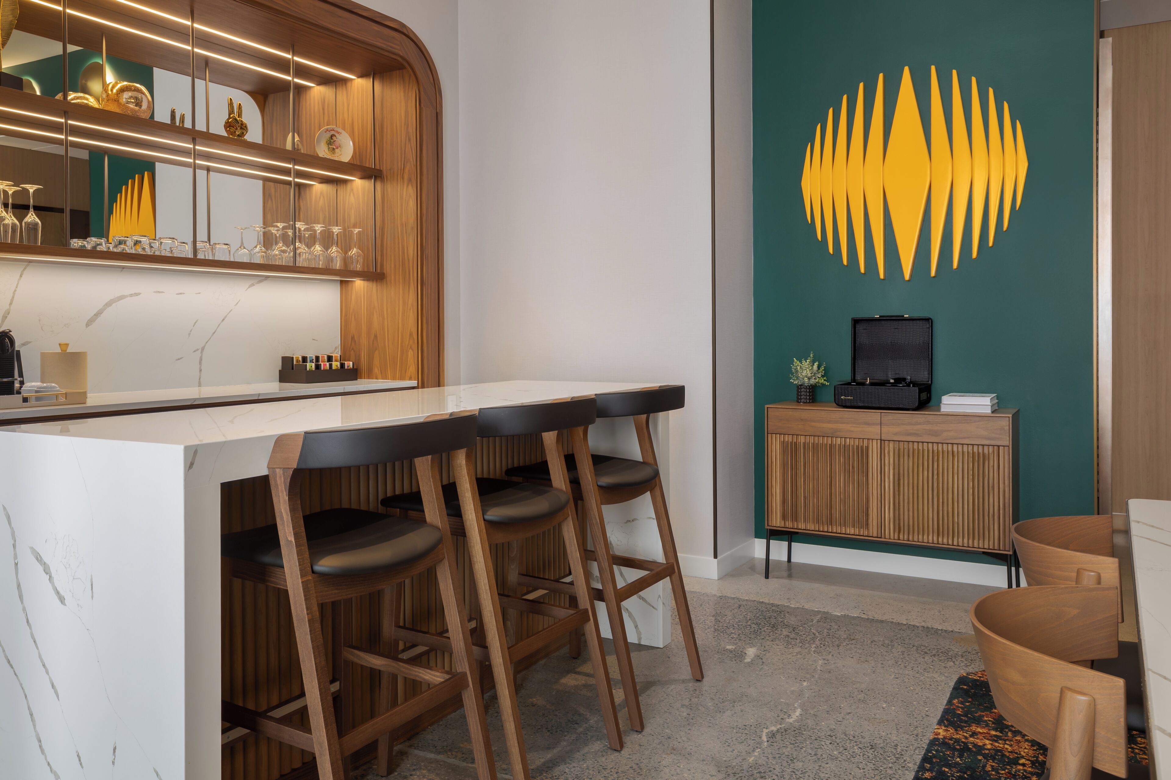 A bar area with stools, a counter, and a television on a cabinet.