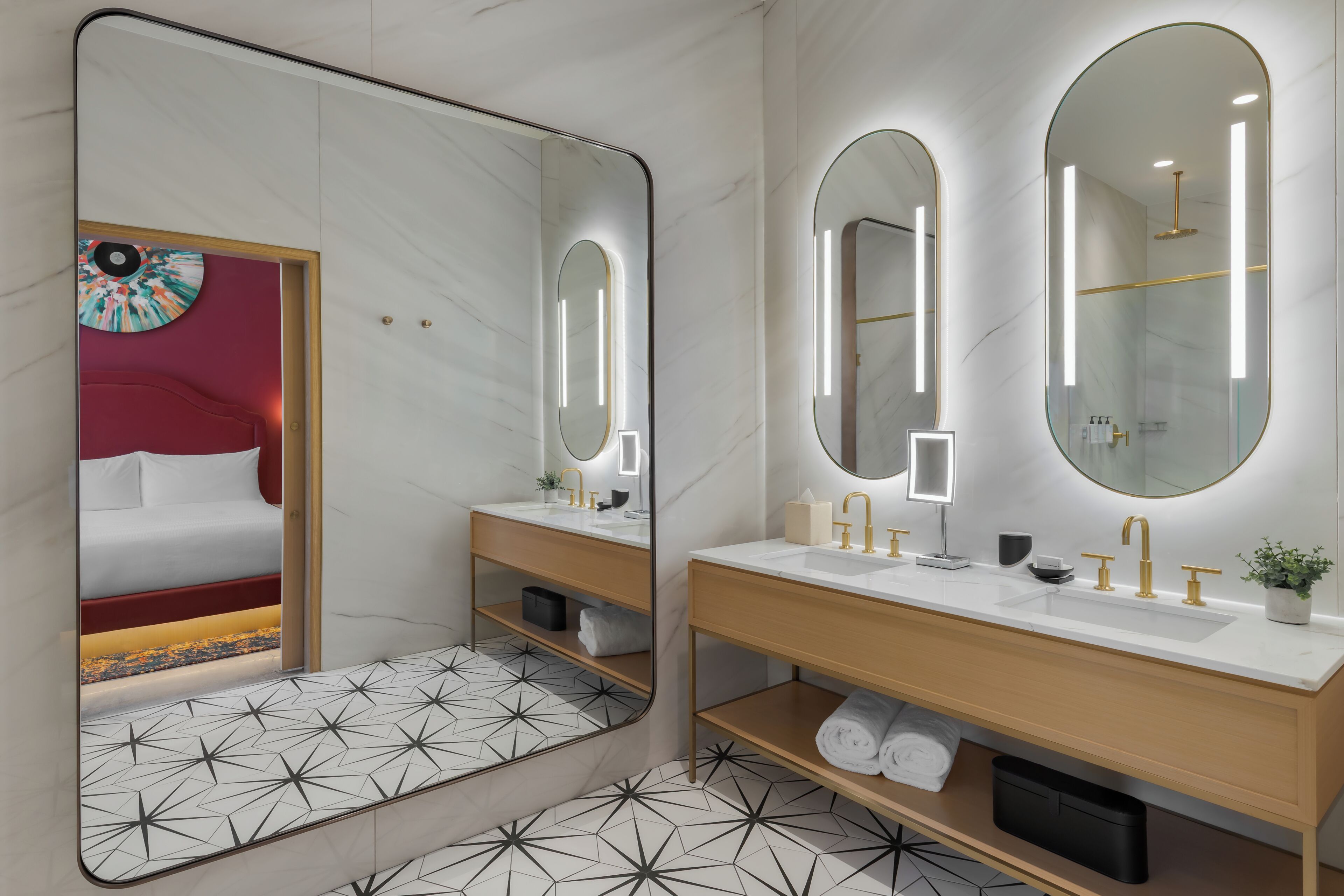 Une salle de bain moderne avec un grand miroir, deux lavabos et un espace douche.