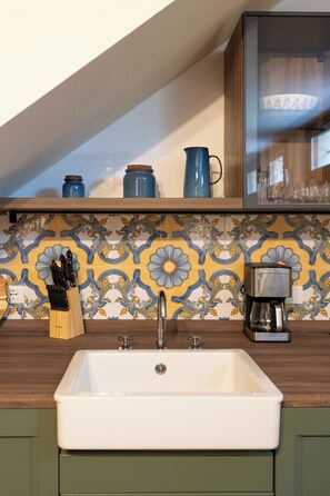 A kitchen with a white sink, a coffee maker, and a knife block. - Villa Acqua Blu: Gorgeous villa walking distance to Lake Garda and its beaches
(Toscolano Maderno)