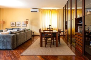 A living room with a sofa, dining table, chairs, and a cabinet. - Villa Acqua Blu: Gorgeous villa walking distance to Lake Garda and its beaches 
 (Toscolano Maderno)