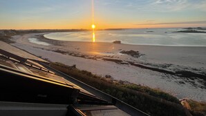 A sunset view from a high vantage point overlooking a beach and water body. - Apartment residence Gulf Stream, Santec, Théven (Santec)