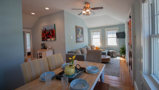 A dining area with a wooden table, chairs, and a ceiling fan. - Charming Beachside Cottage: 3-Bedroom Retreat Steps from Sand, Shops & Dining! (Ogunquit)