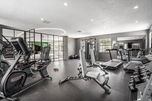 A modern gym with various exercise equipment, including treadmills, weight machines, and free weights.