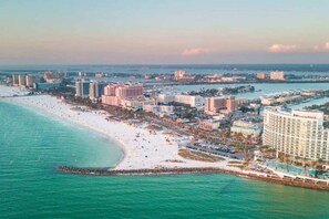 A coastal resort area with beachfront hotels, a sandy beach, and a marina.