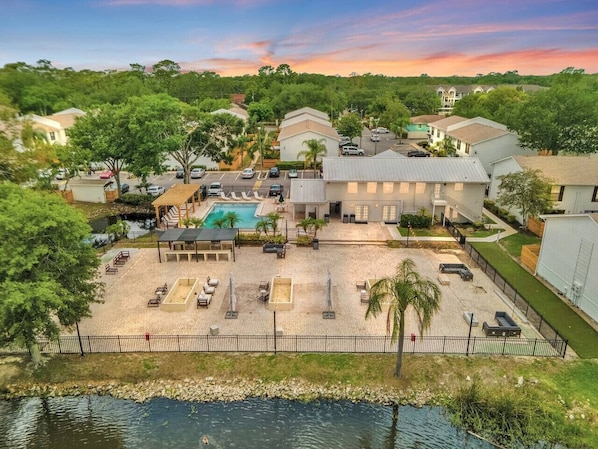 An aerial view of a residential area with a swimming pool, lounge chairs, and a fenced courtyard. - Tampa's Peaceful Retreat (Tampa)