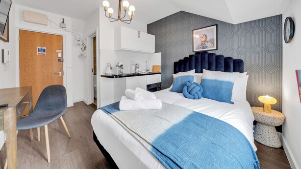 Een moderne hotelkamer met een groot bed, een bureau en een stoel.
