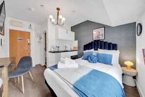 Ein modernes Hotelzimmer mit einem großen Bett, einem Schreibtisch und einem Sessel.