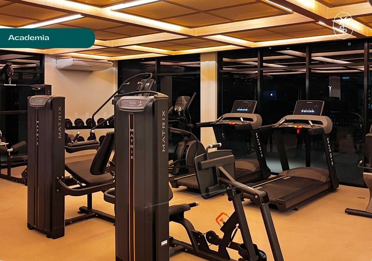A gym with treadmills, weight machines, and dumbbells.