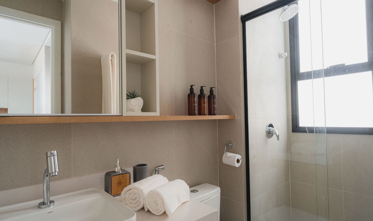 Un bagno moderno con lavandino, toilette e doccia. Sono presenti asciugamani, articoli da toilette e uno specchio.