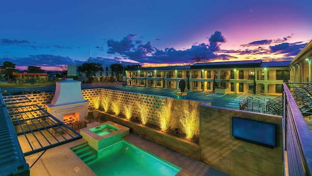 A hotel courtyard with a pool, outdoor seating, and a barbecue area. - Spacious King Room with Modern Comforts – Ideal for Relaxing Getaways! (San Angelo)