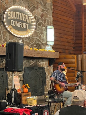 A musician performing on a stage with a stone wall backdrop and a sign reading "Southern Comfort". - SMOKY MTN CHRISTMAS WEEK-2 BEDROOM VILLA (Gatlinburg)