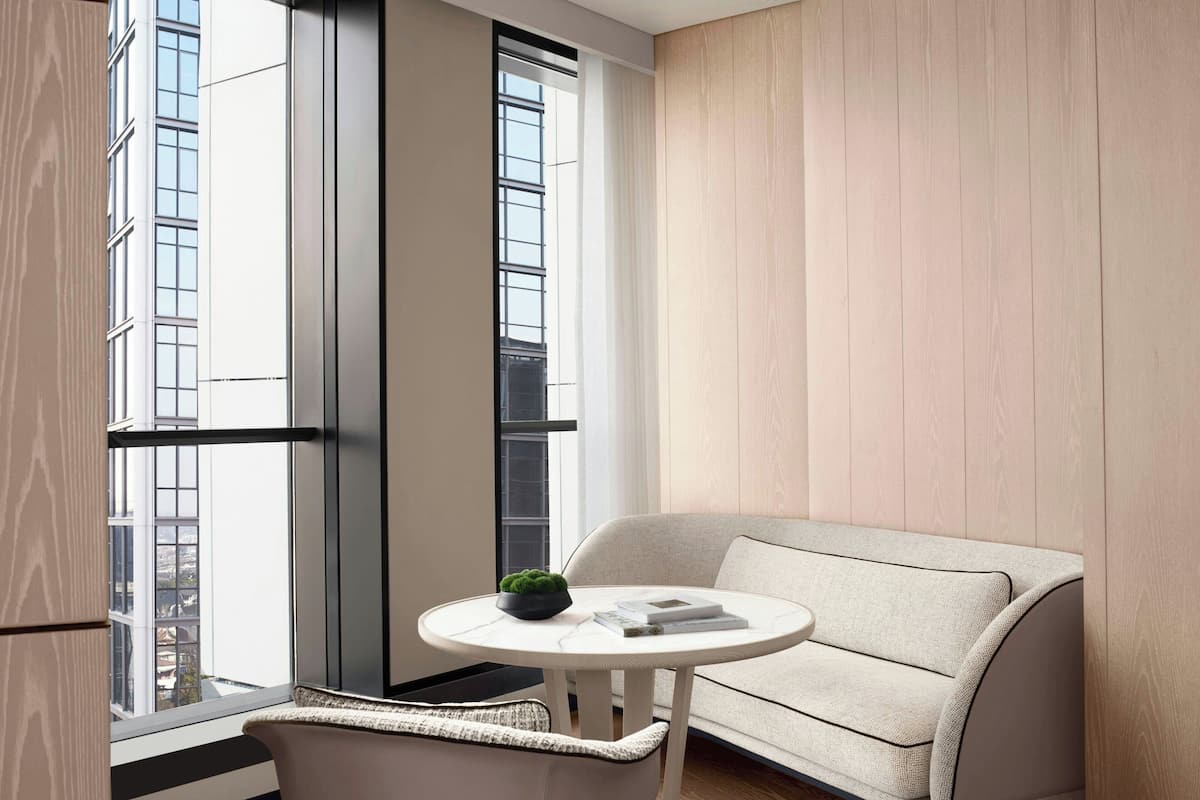 A modern room with a large window, a round table with a plant, and a sofa.