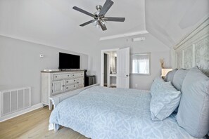 Relax in this inviting bedroom with a large bed, flat-screen TV, and ceiling fan.