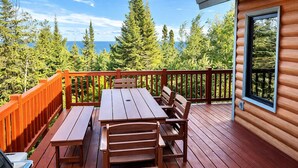 A wooden deck with a table and benches, surrounded by a wooden railing, overlooking a forested area. - Perfect Location|Game Garage|King Beds|Views (Tofte)