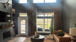A living room with a fireplace, a sofa, a coffee table, and a Christmas tree. - Cozy cabin in lovely Longview with WiFi, AC (Longview)