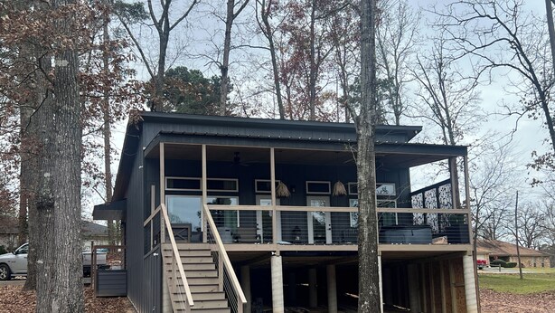 A modern two-story house with a balcony and a staircase leading to the upper floor. - Cozy cabin in lovely Longview with WiFi, AC (Longview)