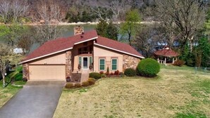 Ein Bungalow mit Garage, Veranda und kleiner Gartenlaube.