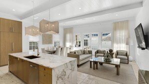 A spacious living area with a marble kitchen island, a sofa set, and a coffee table.