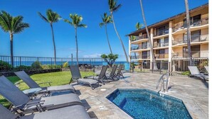 A pool area with lounge chairs, a small pool, and a view of the ocean. - Kona Makai #5203 Ocean View , 
A Hawaiian Paradise (Kailua-Kona)
