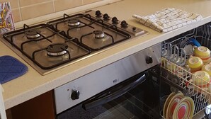 A kitchen with a gas stove, oven, and dishwasher.