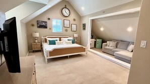A bedroom with a bed, a nightstand, a dresser, a TV, a couch, and a clock on the wall. - The Vine - Elegant "Wild Rose" Cottage on Vineyard with Private Lake, Sleeps 4 (New Ulm)