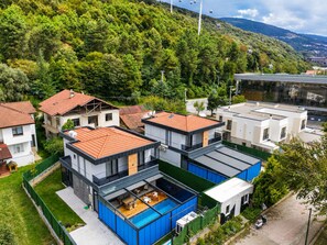 Zona residencial con casas modernas, piscina y vista a la montaña.