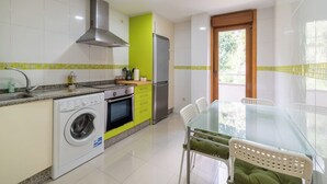 Eine kleine Küche mit Waschmaschine, Herd und Kühlschrank.