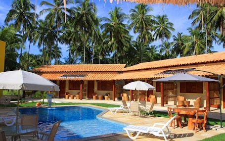 Una piscina al aire libre, sombrillas, sillones reclinables de piscina. POUSADA YAPARATYBA
