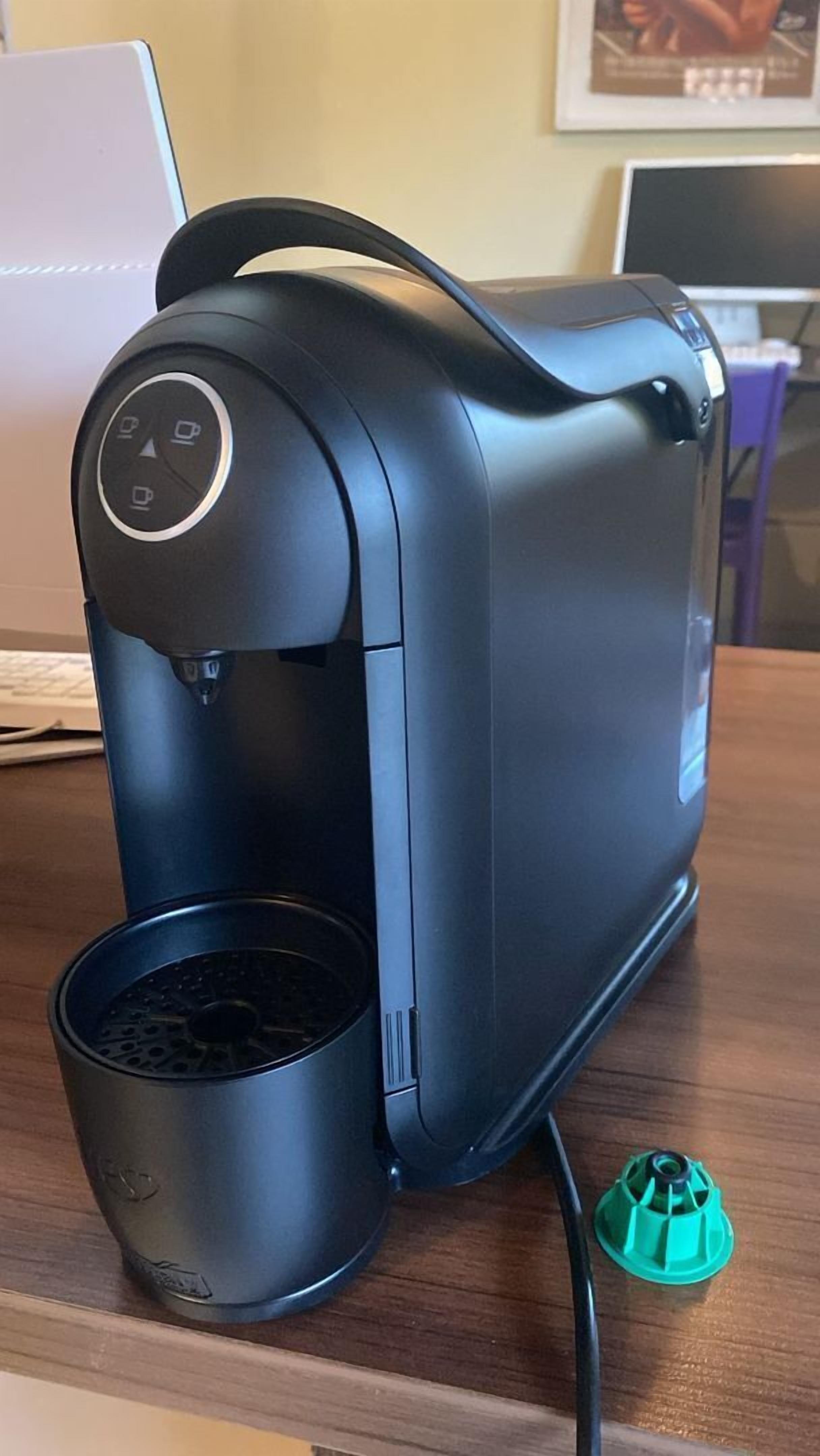 Una cafetera negra con un panel de control sobre una mesa de madera.