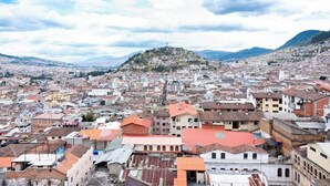 A panoramic view of a city with a prominent hill in the background.