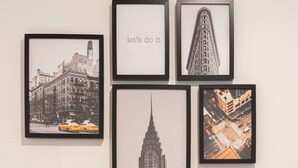 A dining table with framed cityscape photographs, two wine glasses, and plates. - Precioso Loft Puerto Maritimo with Parking (Vigo)