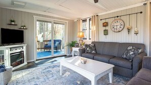 En hyggelig stue med pejs, sofa, sofabord og fjernsyn.