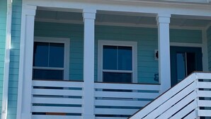 A two-story house with a porch and a staircase. - Nautical Nest in Fort Myers Beach (Fort Myers Beach)