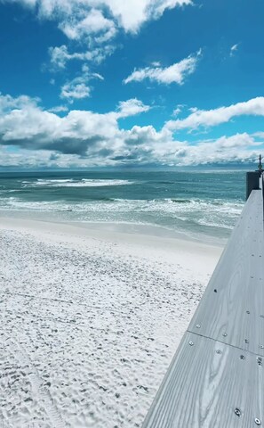 A beach with a wooden boardwalk leading to the ocean.
