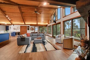 A spacious living area with a large sofa, a dining table, and a kitchen area.
