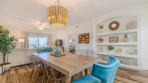 A dining area with a wooden table, blue chairs, and a woven ceiling light fixture.