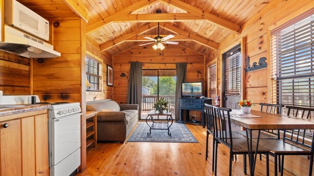 Interno di una baita in legno con cucina, sala da pranzo e zona living.