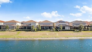 A row of modern houses with a river in the foreground. - Spacious 6-bedroom 5.5 baths Sleeps 16 with a Private Heated Pool/Spa (Davenport)