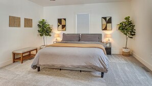 A bedroom with a bed, bedside tables, a bench, a ceiling fan, and two potted plants. - 3 Mi to Downtown Youngstown: Updated Apartment (Youngstown)