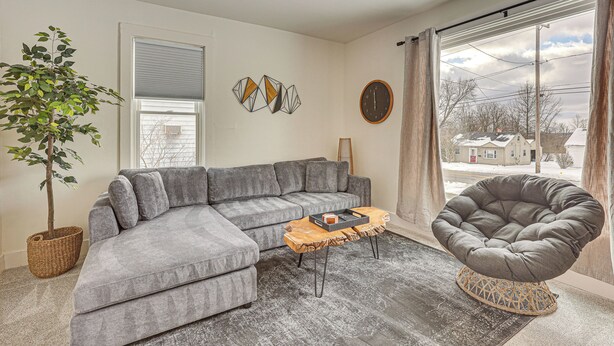 A living room with a grey sectional sofa, a round bean bag chair, a wooden coffee table, a potted plant, and a ceiling fan. - 3 Mi to Downtown Youngstown: Updated Apartment (Youngstown)