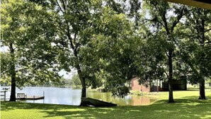 A park with a lake, benches, and trees.