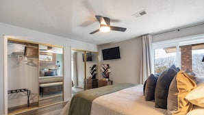 A bedroom with a bed, a ceiling fan, a TV, and a view of the outdoors. - Branson Escape ~ Pointe Royale Resort Condo ~ Pet Friendly ~ Sleeps 6 (Branson)