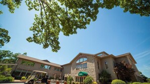 A hotel with a stone facade, a green awning, and a golf cart in the driveway. - Branson Escape ~ Pointe Royale Resort Condo ~ Pet Friendly ~ Sleeps 6 (Branson)