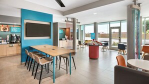 A modern dining area with a long table, chairs, and a coffee station. - avid hotel Plano North by IHG (Plano)
