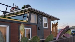 A modern building with a flat roof, large windows, and a door with a sign. - Romantic Houseboat with out of this World Star Gazing (Alpine)