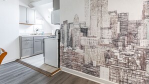 A modern kitchen with grey cabinets, a white countertop, and a built-in oven.